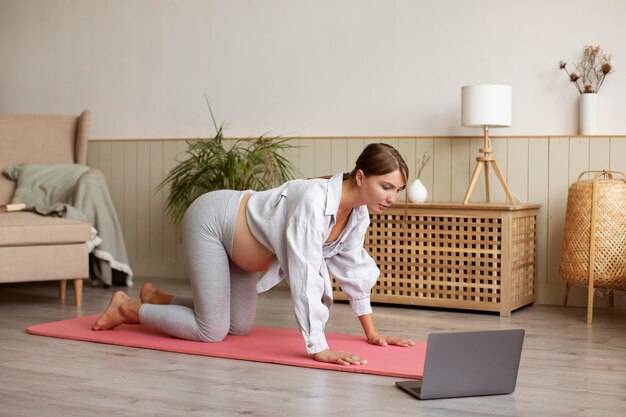 Pregnant woman practicing yoga at home