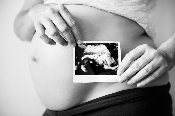 Free Photo pregnant woman showing fetus ultrasound photo