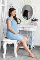 無料写真 ビンテージの椅子に座っている妊娠中の女性