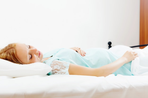 pregnant woman sleeping in  bed