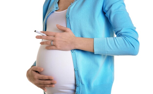 Pregnant woman smoking cigarette on white background