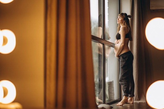 Pregnant woman standing by the window