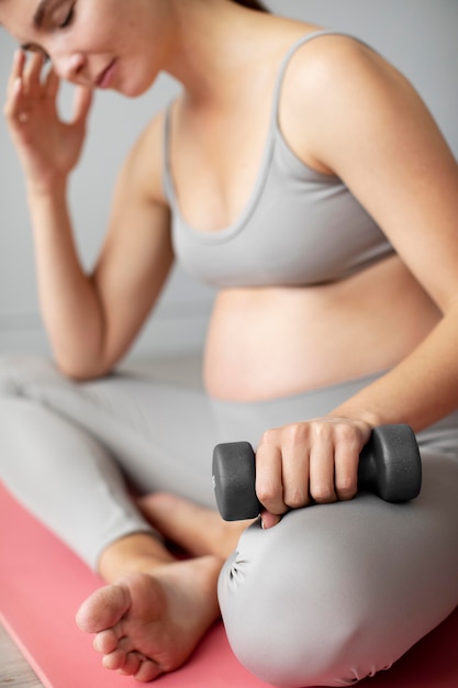 Pregnant woman taking a break from exercising at home