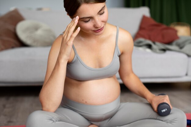 Pregnant woman taking a break from exercising at home