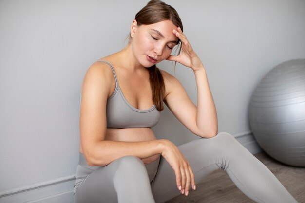 Pregnant woman taking a break from exercising at home