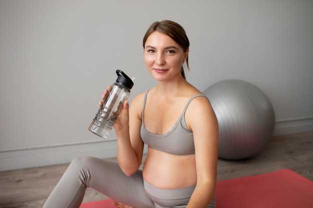 Pregnant woman taking a break from exercising at home