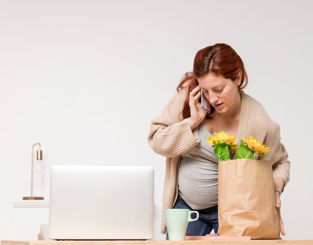 Free photo pregnant woman talking over phone