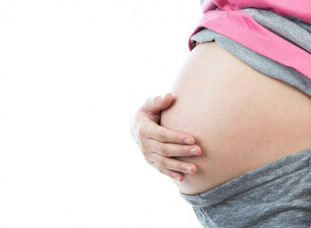 Pregnant woman touching her belly with hand