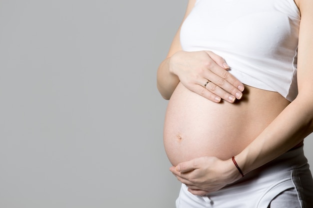 Беременная женщина, касаясь ее живот