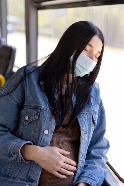 Free photo pregnant woman traveling with mask