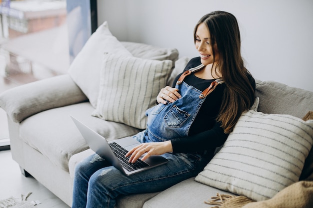 Pregnant woman using computer at home