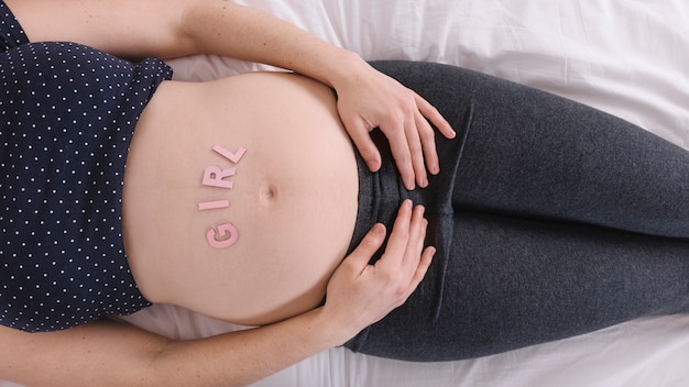 Foto gratuita donna incinta con lettere di ragazza