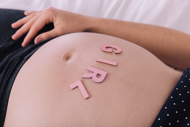 Free photo pregnant woman with girl letters