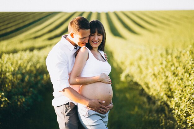 Беременная женщина с мужем в парке