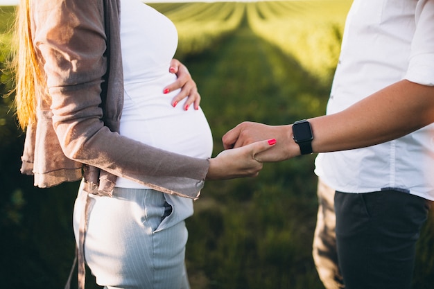 Free photo pregnant woman with her husband in park