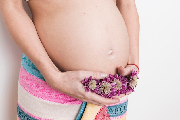 Pregnant woman with towel and flowers