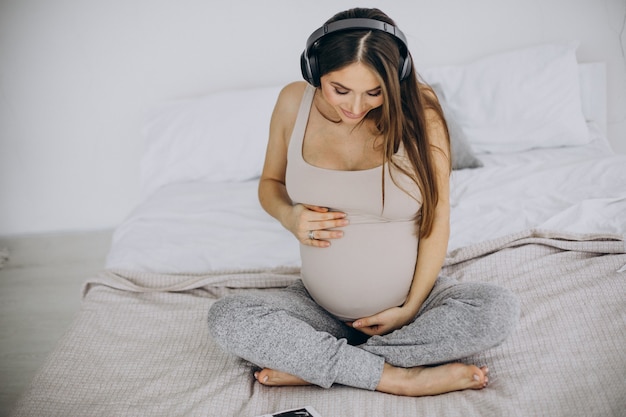 音楽を聴いている超音波写真を持つ妊婦