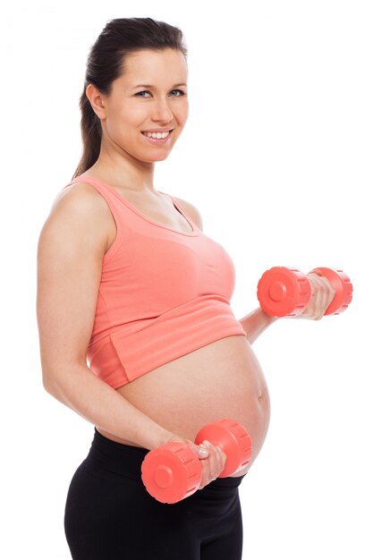 Pregnant woman working out with dumbbells