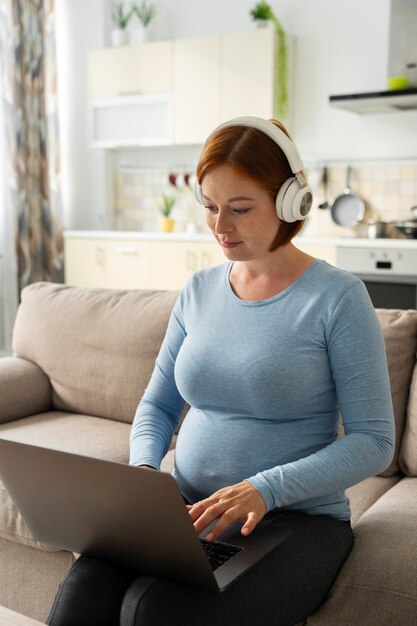 Pregnant woman working remote side view