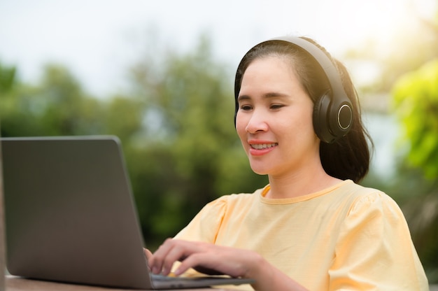 妊娠中の女性はオンラインで買い物をし、自宅でコンピューターを使って音楽を聴きながら仕事をしています。