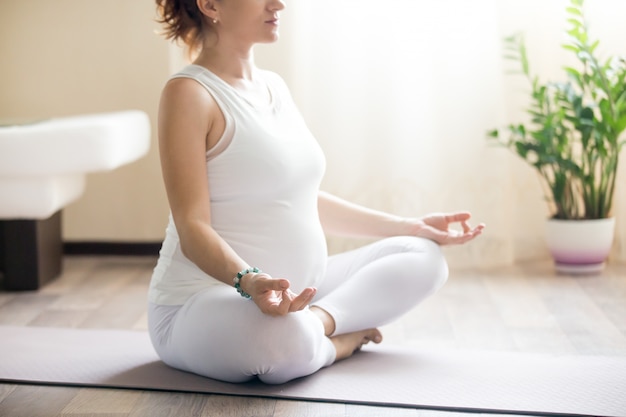 Pregnant yoga woman meditating. Close-up