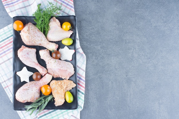 Preparazione per la cena con piatto di cosce di pollo crude.