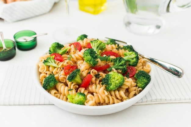 A prepared dish of fusilli with tomato and broccoli