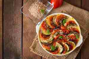 Free photo prepared gratin dish raw eggplant with mozzarella and tomatoes