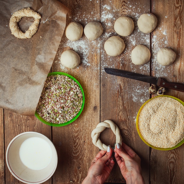 Preparing dough circle by female hands in order to bake simit bread top view