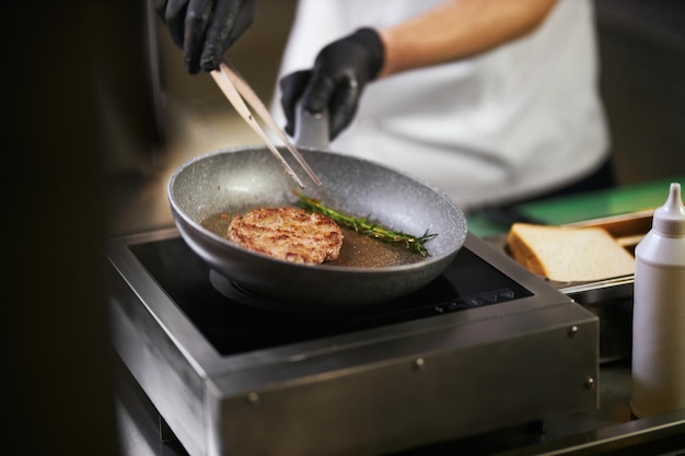 Free photo preparing juicy beef meat with rosemary for burger