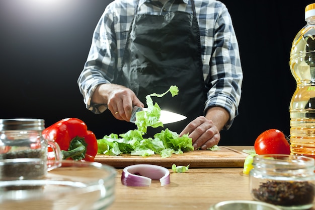 サラダを準備しています。新鮮な野菜を切る女性シェフ。調理プロセス。セレクティブフォーカス。健康食品、キッチン、サラダ、ダイエット、料理の有機コンセプト