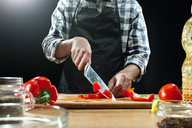 サラダを準備しています。新鮮な野菜を切る女性シェフ。調理プロセス。セレクティブフォーカス