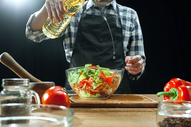 Preparing salad. Female chef cutting fresh vegetables.