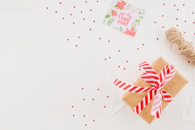 Present box between confetti, threads and post card