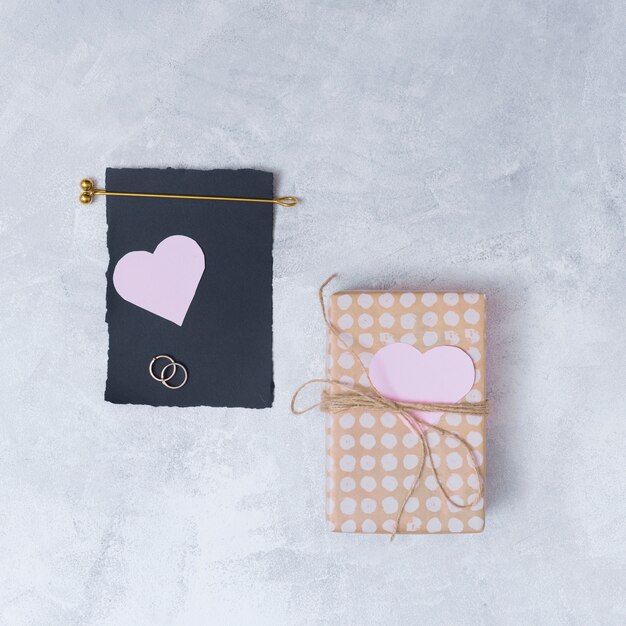 Present box near black paper and symbols of heart