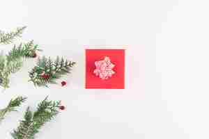 Free photo present box near coniferous branches with flowers