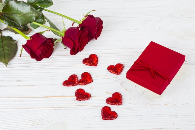 Present box near ornament hearts and flowers