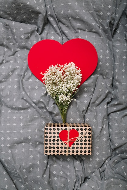 Бесплатное фото Подарочная коробка возле орнамента из бумаги сердца и растений