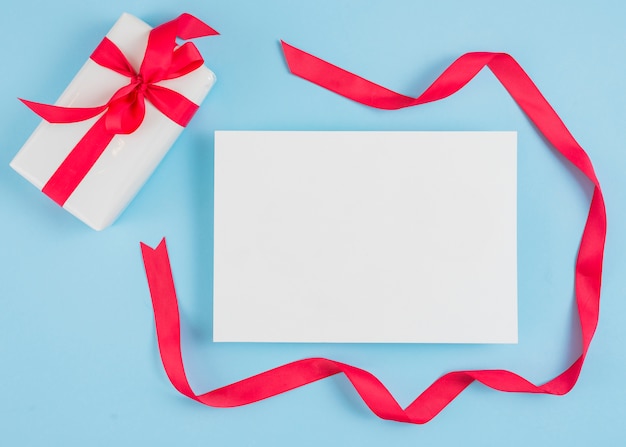 Present box near paper and red ribbon