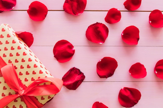 Present box near set of red flower petals