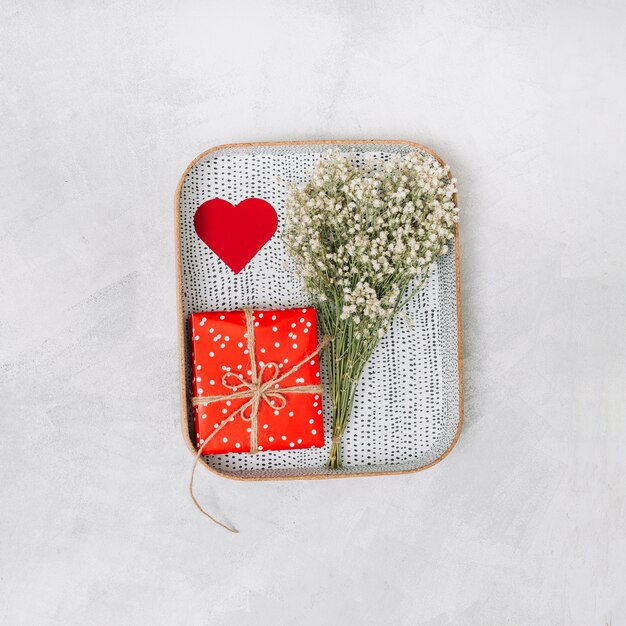 Бесплатное фото Подарочная коробка, украшение сердца и растения на подносе