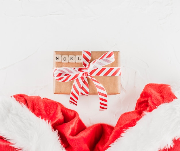 クリスマスの布の近くにノエルタイトルのあるプレゼントボックス