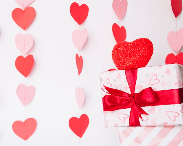 Present box in wrap near decorative paper hearts 