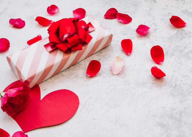 Present box in wrap near flower petals 