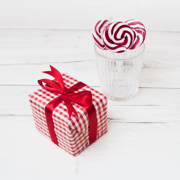 Present box in wrap near glass with lollipops