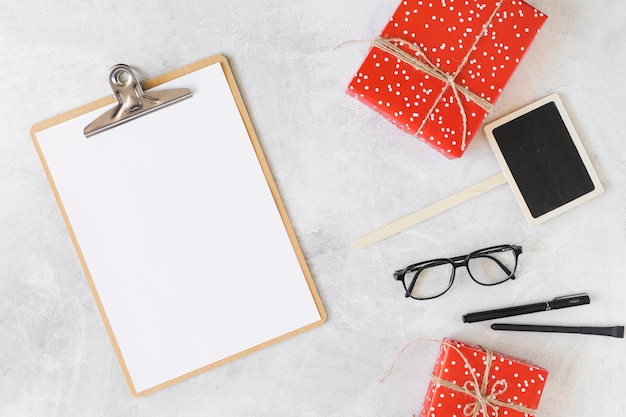 Present boxes, eyeglasses, clipboard and pens 