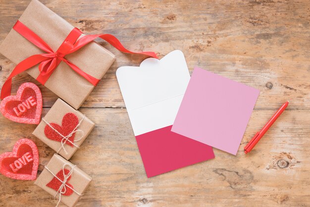 Подарочные коробки возле сердец и бумаг