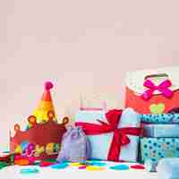 Free photo present boxes with crowns; balloons and shopping bags against pink background