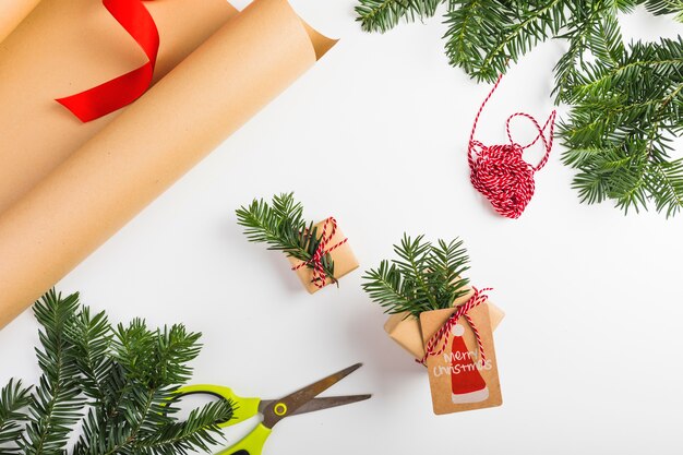 Present boxes with fir twigs and threads near craft paper 