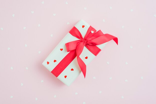 Present and hearts on pink background